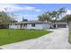 Single-story home with a driveway leading to a detached garage, surrounded by a well-kept lawn at 1610 Stephanie Ln, Lakeland, FL 33813