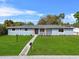 Well-maintained single-story home with a green front yard, concrete walkway and decorative flower beds at 1610 Stephanie Ln, Lakeland, FL 33813