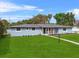 Inviting single-story home featuring a lush front lawn, complemented by neatly arranged flower beds at 1610 Stephanie Ln, Lakeland, FL 33813