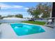 Private backyard featuring a sparkling blue swimming pool and a cozy seating area under a mature tree at 1610 Stephanie Ln, Lakeland, FL 33813