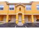 Inviting condo with a yellow painted facade, covered entry, and personal single car garage at 19920 Villa Ridge Dr # 206, Orlando, FL 32821