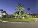 Night view of a landscaped circle with palms and spot lighting enhance the community at 209 Esplanade Way # 109, Casselberry, FL 32707