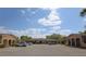 Low-rise community building with beige exterior and asphalt parking lot with several parked cars on a sunny day at 209 Esplanade Way # 109, Casselberry, FL 32707