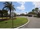 Street view of the community with palm trees and landscaped lawns on a sunny day at 209 Esplanade Way # 109, Casselberry, FL 32707