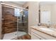 Beautiful bathroom featuring a glass shower with wood-look tile surround and a granite-topped vanity at 2300 Natoma Blvd, Mount Dora, FL 32757