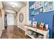 Inviting foyer with wood-look tile flooring, an accent wall with Gathering photos, and console table decor at 2300 Natoma Blvd, Mount Dora, FL 32757