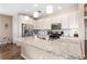 Spacious kitchen with stainless steel appliances, white cabinets, granite countertops, and wood-look flooring at 2300 Natoma Blvd, Mount Dora, FL 32757