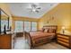 Comfortable bedroom featuring a wooden bed, multiple windows and a dresser at 2864 Polana St # 104, Orlando, FL 32835