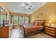 Comfortable bedroom featuring a wooden bed, multiple windows and a dresser at 2864 Polana St # 104, Orlando, FL 32835