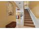 Inviting foyer with travertine floors, arched display niche, and staircase leading to the upper level at 2864 Polana St # 104, Orlando, FL 32835