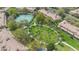 Aerial view of community green space with a walking path, young palm trees and adjacent to a tennis court at 2864 Polana St # 104, Orlando, FL 32835