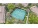 Aerial view of a community tennis court surrounded by trees and adjacent to condo buildings at 2864 Polana St # 104, Orlando, FL 32835