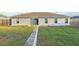 Back exterior view of a home with sliding glass doors, a grass lawn, and a decorative brick path leading to the entrance at 3176 Sw 127Th St, Ocala, FL 34473