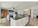 Open layout with kitchen island featuring black countertops and stainless steel appliances, flowing into living and dining areas at 3176 Sw 127Th St, Ocala, FL 34473