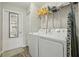 Functional laundry room equipped with modern washer and dryer, storage shelves, and access to additional spaces at 3176 Sw 127Th St, Ocala, FL 34473