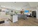 Open-concept living space showcasing a kitchen island, cozy living room, and backyard access via sliding glass doors at 3176 Sw 127Th St, Ocala, FL 34473