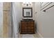 A compact bathroom features a wood vanity with granite countertop and walk-in shower at 3402 Cocard Ct, Windermere, FL 34786