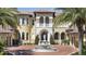 Elegant home featuring a prominent fountain, a grand entrance, and a circular brick driveway at 3402 Cocard Ct, Windermere, FL 34786