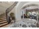 Elegant foyer with a curved staircase, decorative rug, and arched entryway into the living room at 3402 Cocard Ct, Windermere, FL 34786