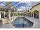 Stunning indoor pool with stone columns, a hot tub and glass-enclosed sunroom in bright light at 3402 Cocard Ct, Windermere, FL 34786