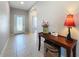 Light and bright foyer with tile flooring, front door with decorative glass, and a console table at 434 Alcove Dr, Groveland, FL 34736