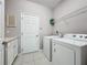 Bright laundry room with ample shelving, modern appliances and tile floor at 434 Alcove Dr, Groveland, FL 34736