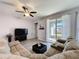 Cozy living room featuring wood floors, a comfortable sectional sofa, and sliding glass doors at 434 Alcove Dr, Groveland, FL 34736