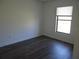 Light filled bedroom showcasing dark wood-look floors and a window at 445 Live Oak Ave, Chuluota, FL 32766