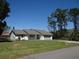 Well-maintained home featuring a two-car garage, a green lawn, and mature trees at 445 Live Oak Ave, Chuluota, FL 32766