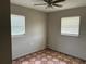 A cozy bedroom featuring natural light from the two windows and tile flooring at 4845 Elese St, Orlando, FL 32811
