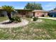Charming single-story home featuring a covered porch and unique landscaping in the front yard at 4845 Elese St, Orlando, FL 32811