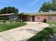Charming one-story home featuring a covered porch and a long concrete driveway at 4845 Elese St, Orlando, FL 32811