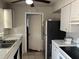 Kitchen with a double sink, white cabinets, black appliances, and access to another room at 4845 Elese St, Orlando, FL 32811