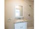 This bright bathroom features modern vanity, granite countertop, a mirror, and a walk-in shower at 4906 Cortez Dr, Orlando, FL 32808