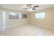 An inviting bedroom featuring tile flooring, natural light from three windows, and a ceiling fan at 4906 Cortez Dr, Orlando, FL 32808