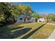 Single-Gathering home with a well-manicured lawn, mature trees, and a partially brick driveway at 4906 Cortez Dr, Orlando, FL 32808