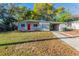 Charming single-story home featuring a bright red front door and a well-maintained front yard at 4906 Cortez Dr, Orlando, FL 32808