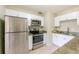 Bright kitchen features stainless steel appliances and granite countertops with white cabinets at 4906 Cortez Dr, Orlando, FL 32808