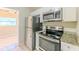 Bright kitchen features stainless steel appliances and granite countertops with white cabinets at 4906 Cortez Dr, Orlando, FL 32808