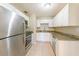 Updated kitchen features stainless steel appliances, granite countertops, and white cabinetry at 4906 Cortez Dr, Orlando, FL 32808