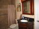 Bathroom featuring tiled shower, vanity with dark granite countertop, and decorative mirror at 506 Freeman St, Longwood, FL 32750