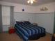 Bedroom featuring a blue striped bedspread, window with curtain, and two-tone walls at 506 Freeman St, Longwood, FL 32750