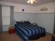 Inviting bedroom with a brass bed frame, blue striped bedding, and stool at 506 Freeman St, Longwood, FL 32750