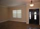 Neutral living room featuring tile flooring, a window, and an entryway with a decorated glass door at 506 Freeman St, Longwood, FL 32750