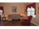 Comfortable living room featuring a floral sofa, accent chair, and neutral color palette at 506 Freeman St, Longwood, FL 32750