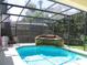 Outdoor pool with a waterfall feature, screened-in enclosure, and beautiful landscaping, perfect for relaxation at 506 Freeman St, Longwood, FL 32750