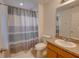 Standard bathroom with tiled floors, framed mirror, and shower featuring curtain at 5201 Villa Rosa Ave, St Cloud, FL 34771