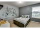 Inviting bedroom featuring sports-themed artwork, and natural light streaming through the window at 5201 Villa Rosa Ave, St Cloud, FL 34771