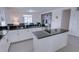 Modern kitchen featuring white cabinets, black countertops, an island, and a stylish backsplash wall at 5201 Villa Rosa Ave, St Cloud, FL 34771