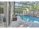 A refreshing screened in pool with brick pavers and green foliage at 6145 Froggatt St, Orlando, FL 32835